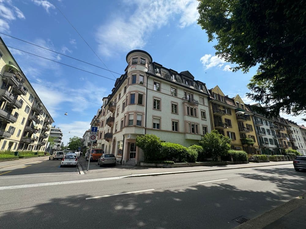 Eckhaus in europäischer Stadt mit blauem Himmel und Straßenkreuzung.